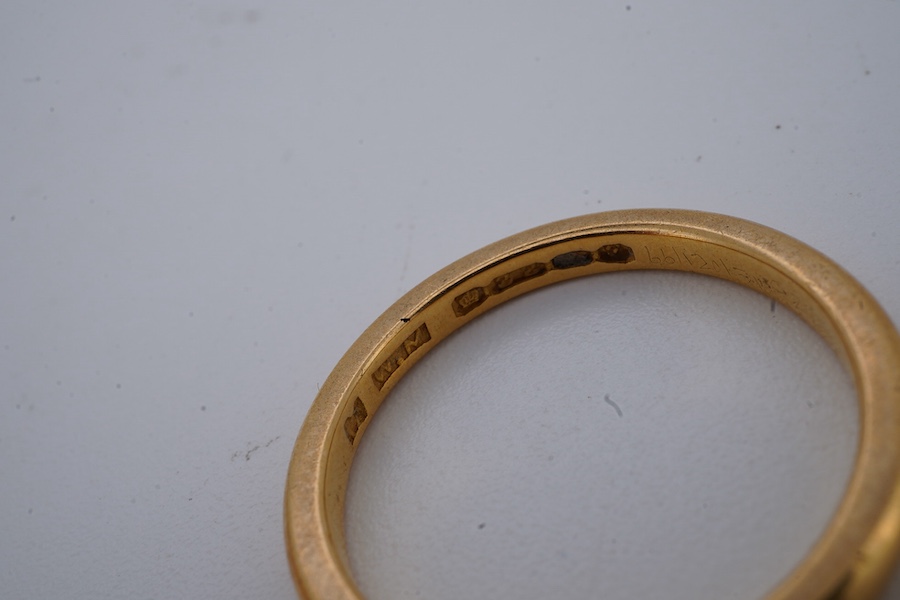 Four gold rings, comprising: a 22ct gold wedding band, size M, British assay marks, gross weight 3 grams; a 9ct gold band with a panelled finish, size N, British hallmarks, gross weight approximately 3.5 grams; a bicolou